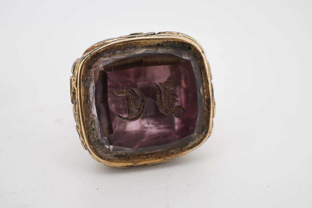 A 19th century yellow metal overlaid and bloodstone set fob seal, the matrix carved with a griffin and motto 'Opus Coronat Finis', 30mm, together with a similar gold plated fob seal and foil backed quartz fob seal, the m
